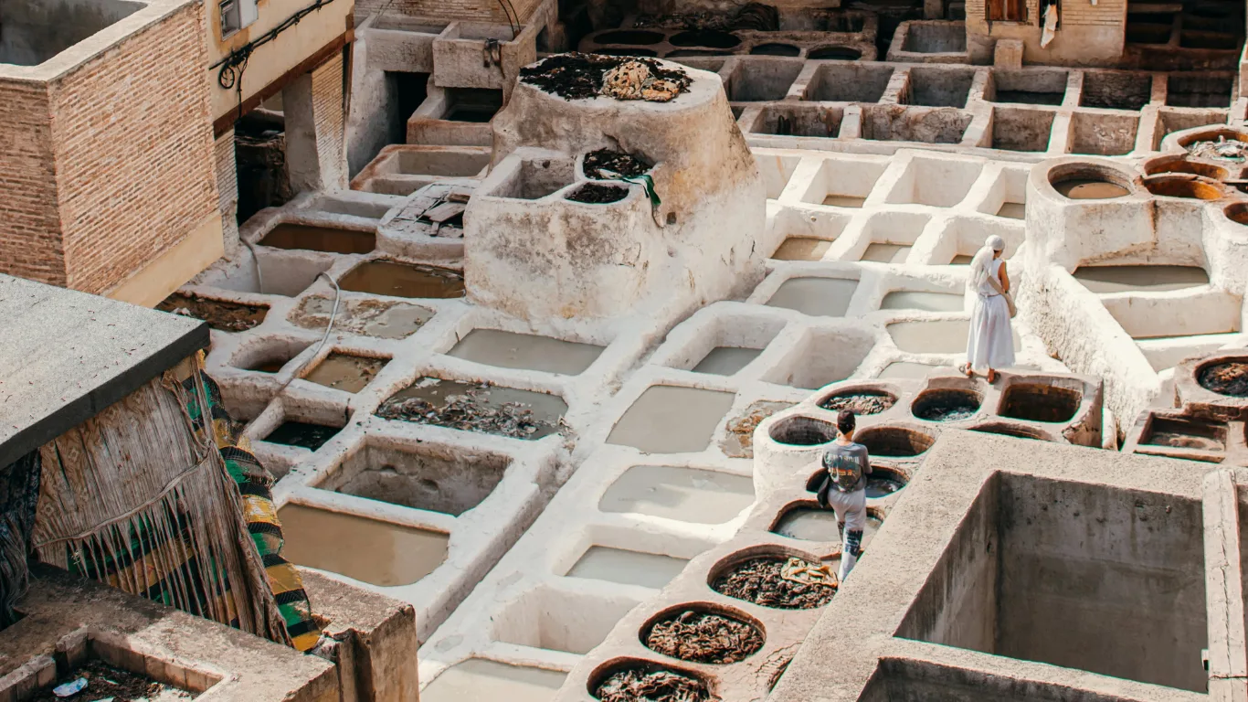 Two tourists explore the ancient Chouara Tannery in Fes, Morocco, during a 3 days tour from Fes to Marrakech.