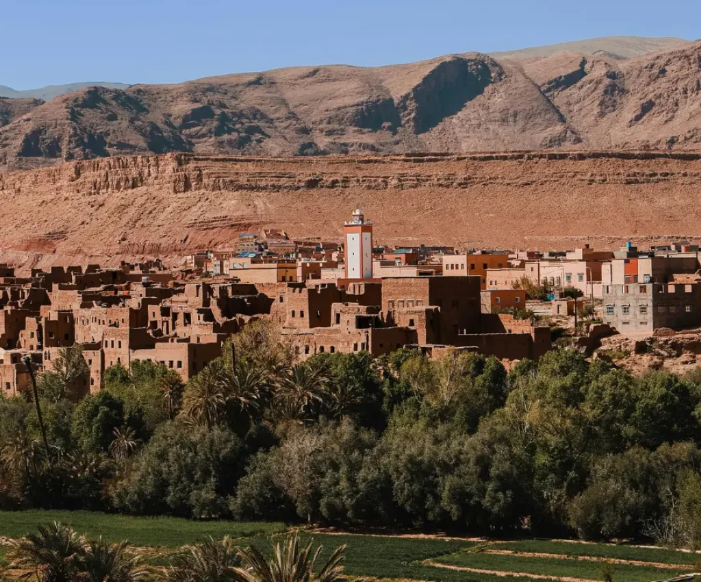 3 Days 2 Nights from Marrakech to Merzouga – Berber Village & Atlas Foothills Traditional Berber village with earthen houses and mosque nestled at the foot of the Atlas Mountains on a 3-day Marrakech to Merzouga tour.